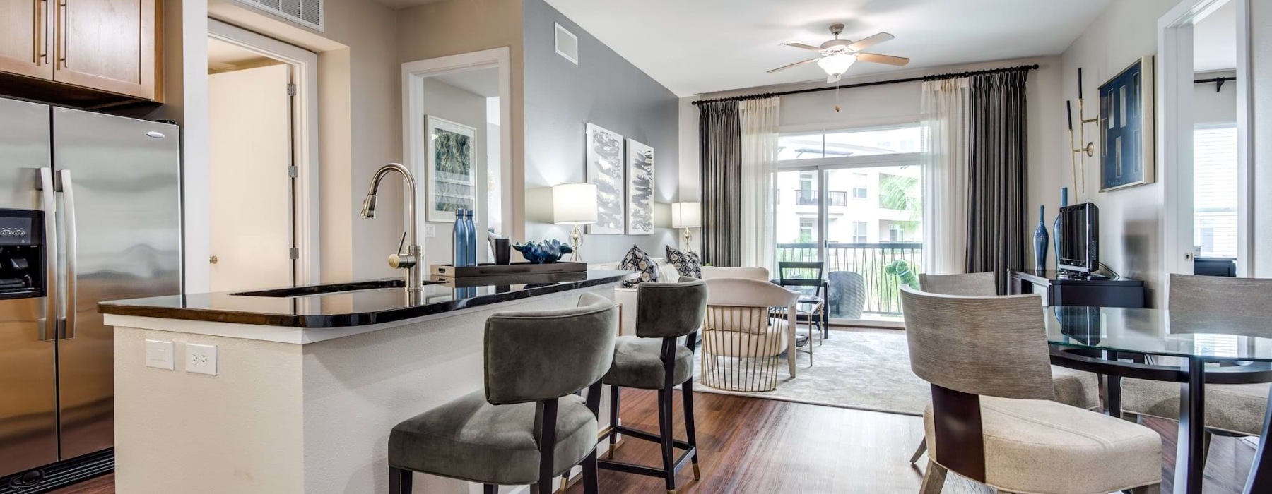 Open kitchen with dining area and living room at Domain at City Centre apartments in Houston.