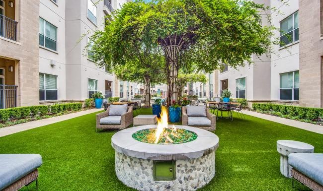 Cutting-edge amenities at your fingertips a courtyard with a fire pit, tables and chairs