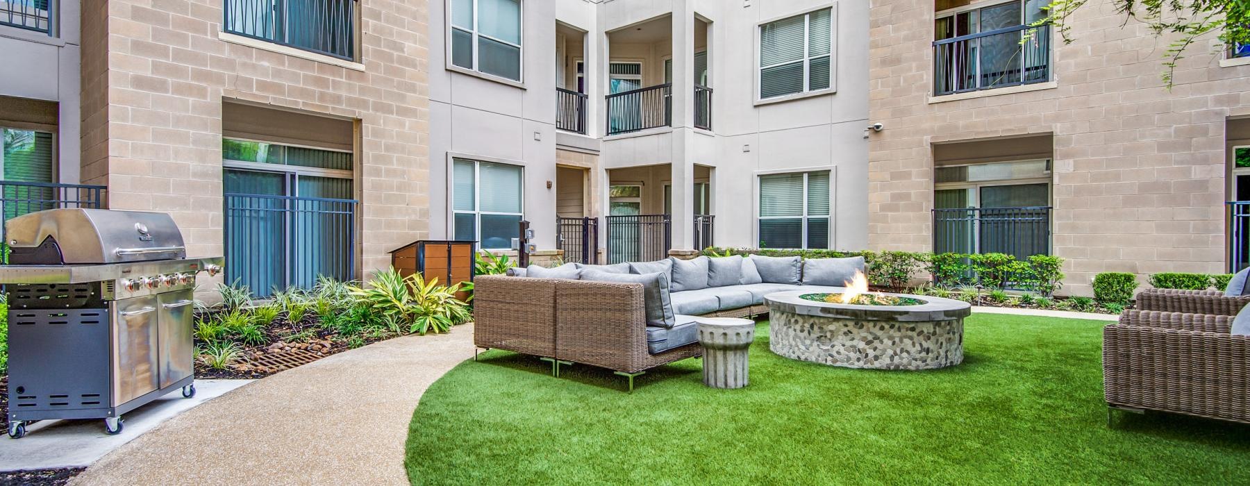 a courtyard with a fire pit and a building in the background